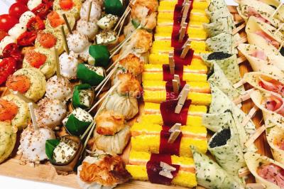 Logo d'un traiteur avec silhouette de chef et couverts, accompagné de photos de bouchées et plats variés colorés.