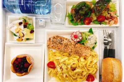 Logo d'un traiteur avec silhouette de chef et couverts, accompagné de photos de bouchées et plats variés colorés.