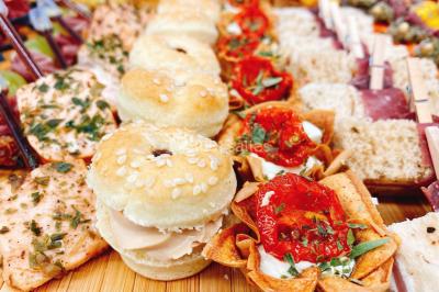 Logo d'un traiteur avec silhouette de chef et couverts, accompagné de photos de bouchées et plats variés colorés.