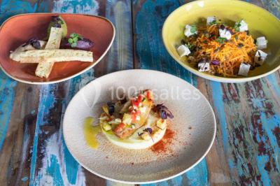 Table garnie de fruits variés et colorés, disposés artistiquement avec des feuilles tropicales en arrière-plan.