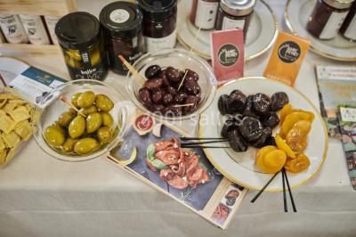 Table garnie de fruits variés et colorés, disposés artistiquement avec des feuilles tropicales en arrière-plan.