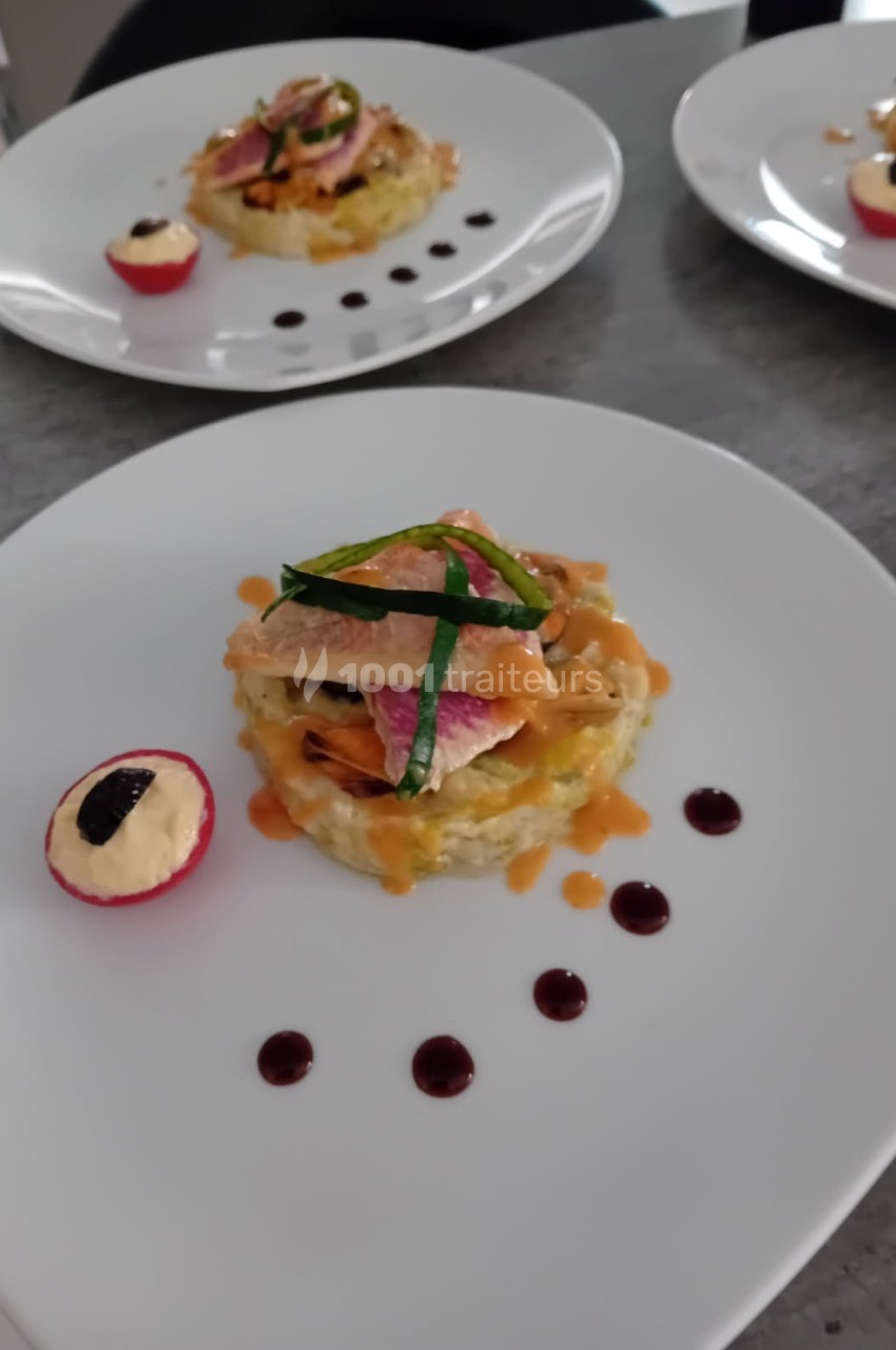 Assiette dressée avec un plat raffiné composé de poisson, légumes, sauce et une garniture de radis farci.