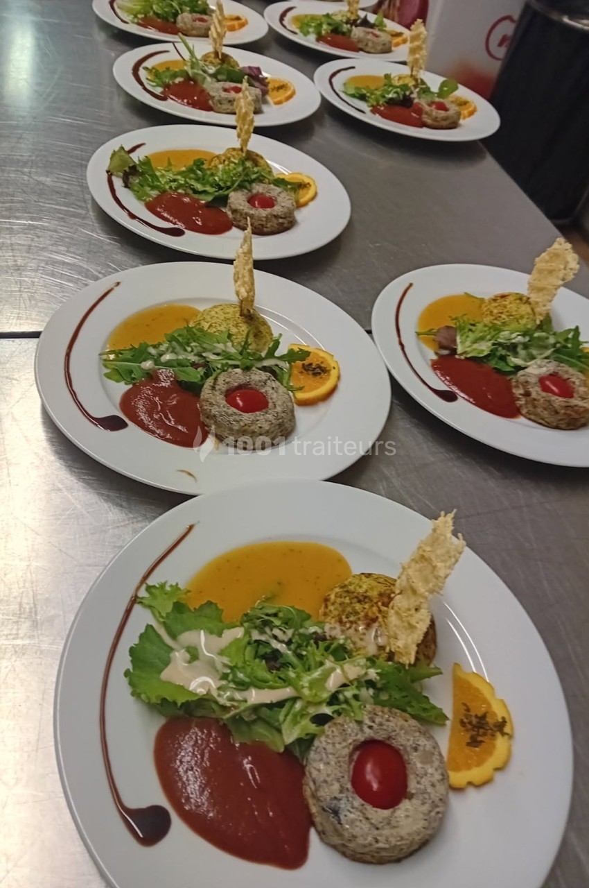 Assiettes dressées avec des portions de légumes, purées, sauces et décorations croustillantes sur une table en inox.