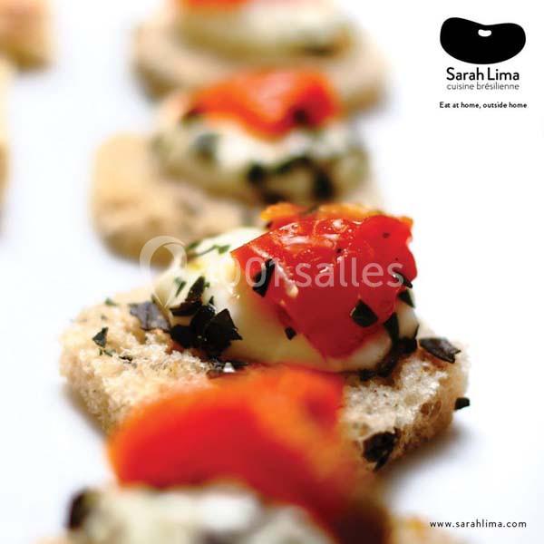 Tranches de pain garnies de fromage fondu, tomates et herbes, présentées en gros plan sur une table.