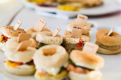 Miniature Traiteur Élancourt (Yvelines) - Sarah Lima Traiteur Brésilien #5 Salle de réception décorée avec des tables alignées, nappes blanches, chaises pliantes et ornements suspendus.