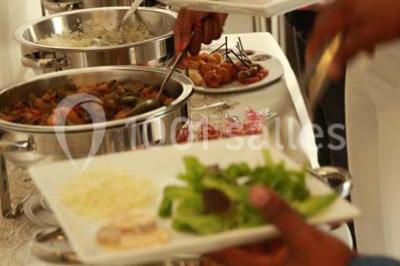 Miniature Traiteur Élancourt (Yvelines) - Sarah Lima Traiteur Brésilien #15 Salle de réception décorée avec des tables alignées, nappes blanches, chaises pliantes et ornements suspendus.