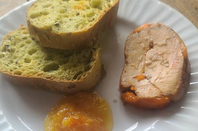 Plat composé d'une cuisse de volaille nappée de sauce, pommes de terre rôties et roulé de légumes en forme de fleur.