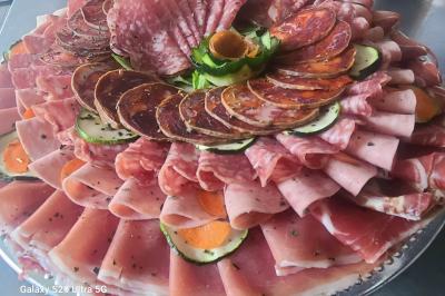 Plat composé d'une cuisse de volaille nappée de sauce, pommes de terre rôties et roulé de légumes en forme de fleur.