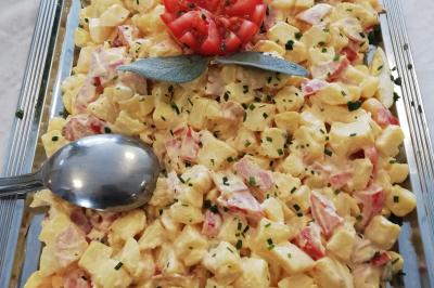 Plat composé d'une cuisse de volaille nappée de sauce, pommes de terre rôties et roulé de légumes en forme de fleur.