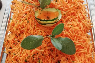 Plat composé d'une cuisse de volaille nappée de sauce, pommes de terre rôties et roulé de légumes en forme de fleur.