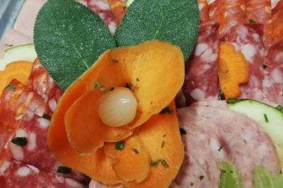 Plat composé d'une cuisse de volaille nappée de sauce, pommes de terre rôties et roulé de légumes en forme de fleur.