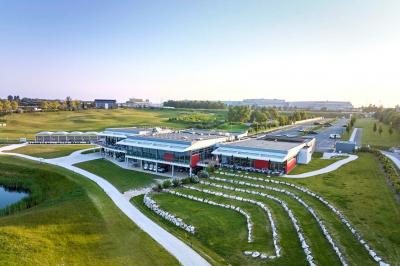 Salle de réception décorée avec des tables dressées, des chaises ornées de nœuds roses et des bouquets de fleurs.