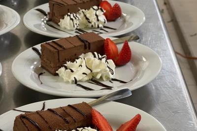 Miniature Traiteur Beauchamp (Val-d'Oise) - L'instant Gourmand #26 Assiettes de pastillas saupoudrées de sucre glace, accompagnées de salade verte, légumes frais et fleurs comestibles.