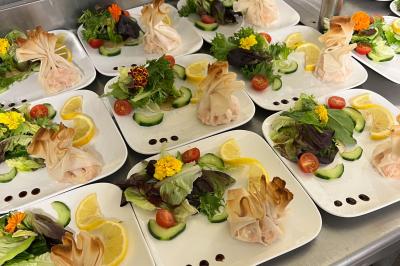 Miniature Traiteur Beauchamp (Val-d'Oise) - L'instant Gourmand #29 Assiettes de pastillas saupoudrées de sucre glace, accompagnées de salade verte, légumes frais et fleurs comestibles.