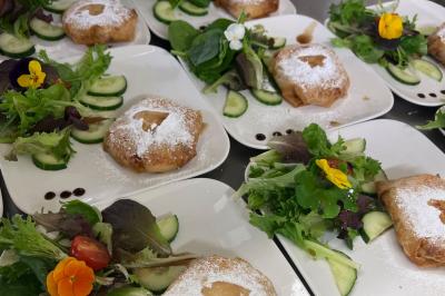 Miniature Traiteur Beauchamp (Val-d'Oise) - L'instant Gourmand #30 Assiettes de pastillas saupoudrées de sucre glace, accompagnées de salade verte, légumes frais et fleurs comestibles.