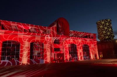 Salle équipée de plusieurs écrans, éclairages bleus et matériel audiovisuel, prête pour un événement ou une présentation.