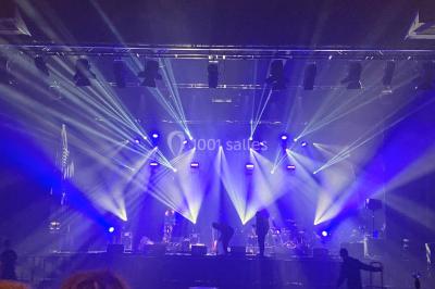 Salle équipée de plusieurs écrans, éclairages bleus et matériel audiovisuel, prête pour un événement ou une présentation.