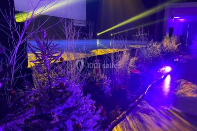 Salle équipée de plusieurs écrans, éclairages bleus et matériel audiovisuel, prête pour un événement ou une présentation.