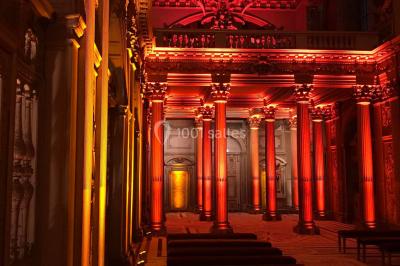 Salle équipée de plusieurs écrans, éclairages bleus et matériel audiovisuel, prête pour un événement ou une présentation.