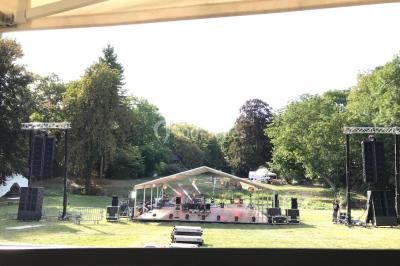 Salle équipée de plusieurs écrans, éclairages bleus et matériel audiovisuel, prête pour un événement ou une présentation.