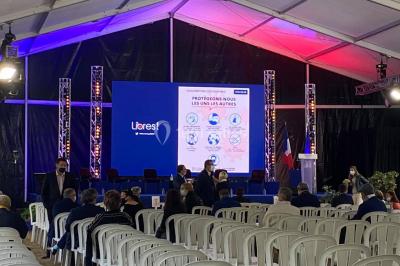 Salle équipée de plusieurs écrans, éclairages bleus et matériel audiovisuel, prête pour un événement ou une présentation.