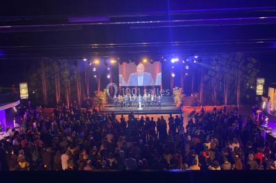 Salle équipée de plusieurs écrans, éclairages bleus et matériel audiovisuel, prête pour un événement ou une présentation.