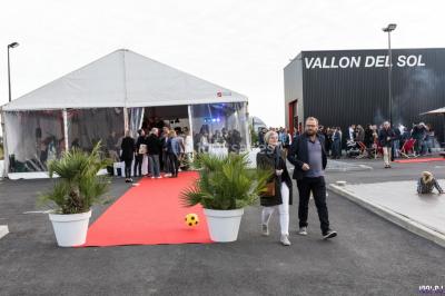 Groupe de personnes dans une salle éclairée par des lumières roses, certaines tenant des bougies.