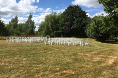 Groupe de personnes dans une salle éclairée par des lumières roses, certaines tenant des bougies.