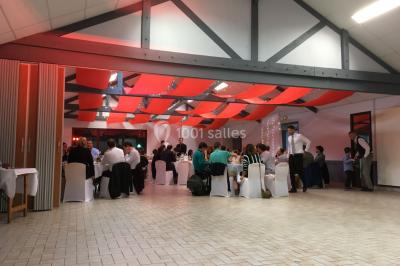 Groupe de personnes dans une salle éclairée par des lumières roses, certaines tenant des bougies.