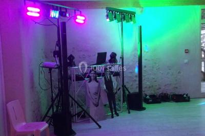 Groupe de personnes dans une salle éclairée par des lumières roses, certaines tenant des bougies.