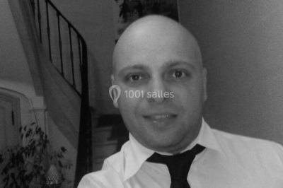 Un couple en tenue de mariage pose devant des lumières colorées dans une ambiance festive.