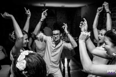 Un couple en tenue de mariage pose devant des lumières colorées dans une ambiance festive.