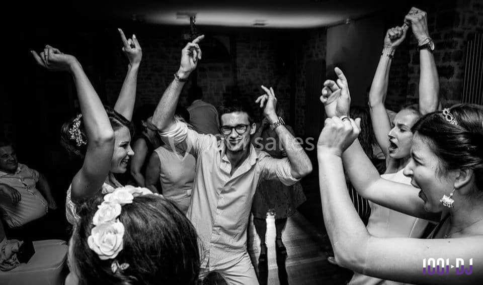 Des personnes dansent et célèbrent ensemble dans une ambiance festive, dans une pièce à éclairage tamisé.