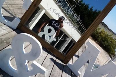 Un couple en tenue de mariage pose devant des lumières colorées dans une ambiance festive.