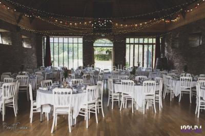 Un couple en tenue de mariage pose devant des lumières colorées dans une ambiance festive.