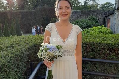 Un couple en tenue de mariage pose devant des lumières colorées dans une ambiance festive.