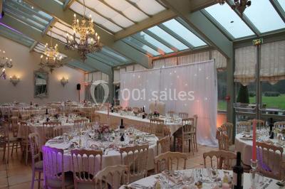Ruelle pavée bordée de fleurs, avec un puits en pierre et des bâtiments anciens sous un ciel ensoleillé.