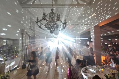 Ruelle pavée bordée de fleurs, avec un puits en pierre et des bâtiments anciens sous un ciel ensoleillé.