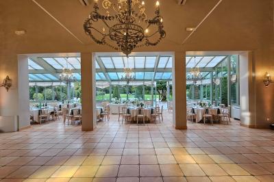 Ruelle pavée bordée de fleurs, avec un puits en pierre et des bâtiments anciens sous un ciel ensoleillé.