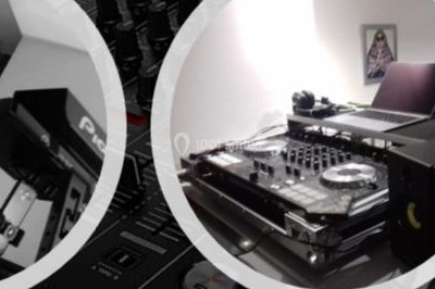 Un homme portant un casque audio mixe de la musique sur un ordinateur portable et un équipement de DJ.