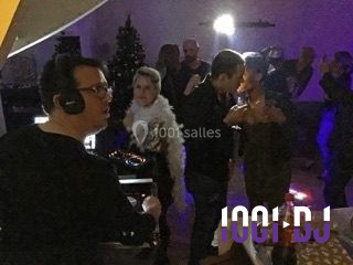 Un homme portant un casque audio mixe de la musique sur un ordinateur portable et un équipement de DJ.