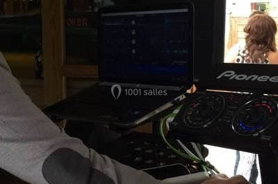 Un homme portant un casque audio mixe de la musique sur un ordinateur portable et un équipement de DJ.