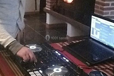 Un homme portant un casque audio mixe de la musique sur un ordinateur portable et un équipement de DJ.