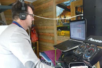 Un homme portant un casque audio mixe de la musique sur un ordinateur portable et un équipement de DJ.