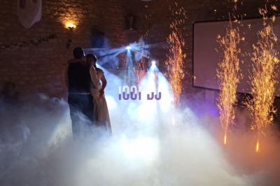 Salle de réception avec scène éclairée par des projecteurs orange, décorée de ballons suspendus.