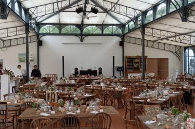Salle de réception avec scène éclairée par des projecteurs orange, décorée de ballons suspendus.