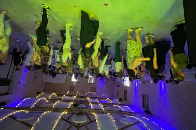 Salle de réception avec scène éclairée par des projecteurs orange, décorée de ballons suspendus.