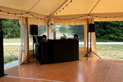 Salle de réception avec scène éclairée par des projecteurs orange, décorée de ballons suspendus.