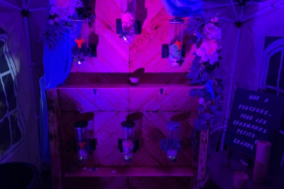 Salle de réception avec scène éclairée par des projecteurs orange, décorée de ballons suspendus.