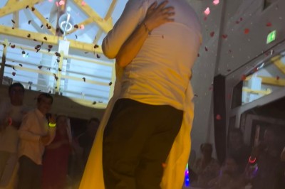 Salle de réception avec scène éclairée par des projecteurs orange, décorée de ballons suspendus.